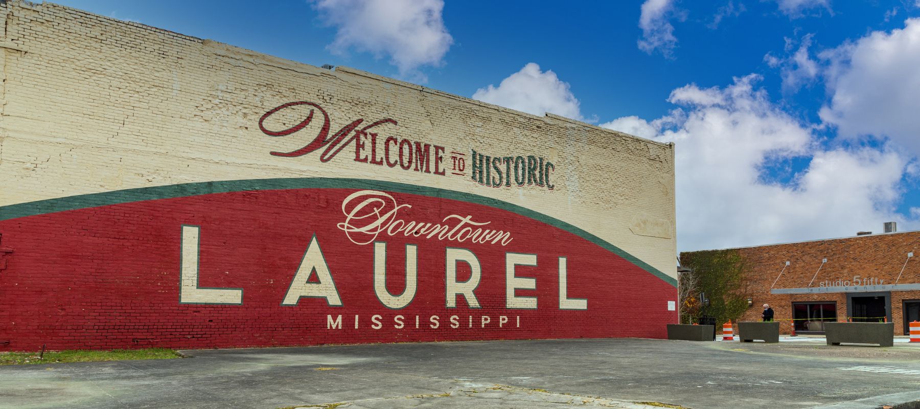 Historic downtown mural in Laurel, Mississippi painted on a brick wall with clear skies above